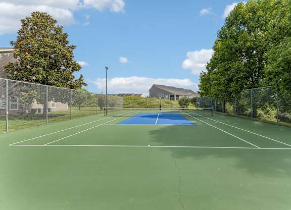 A tennis court with a blue surface and white lines.