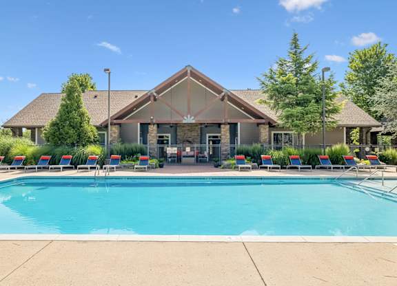 A large house with a pool in front.