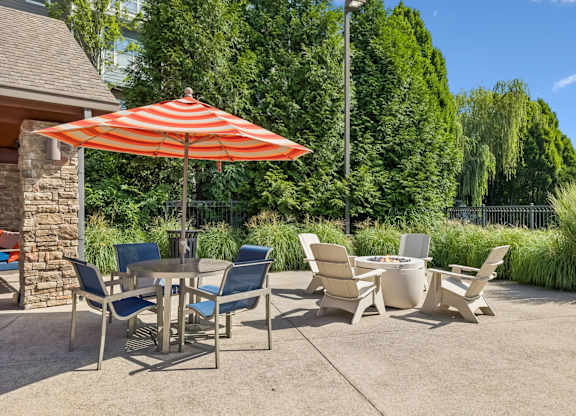 A patio with a table and chairs under an umbrella.