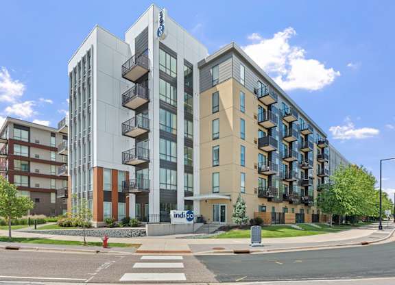 A modern apartment building with a glass facade and balconies.