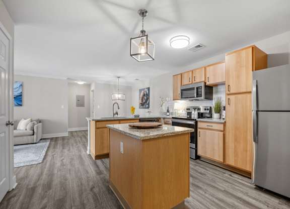 A kitchen with a refrigerator, microwave, and oven.
