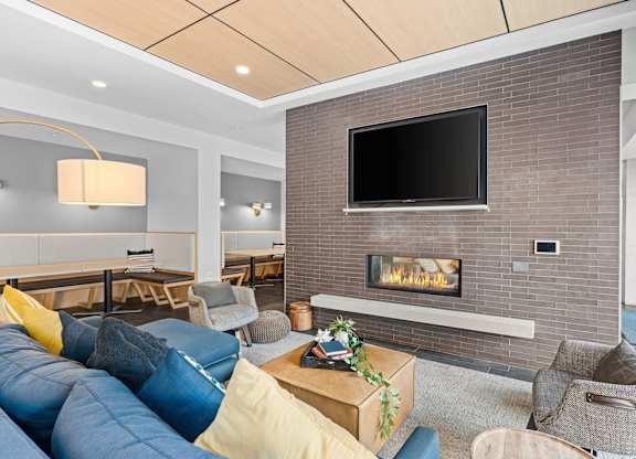 A modern living room with a fireplace and a flat screen TV mounted on the wall.