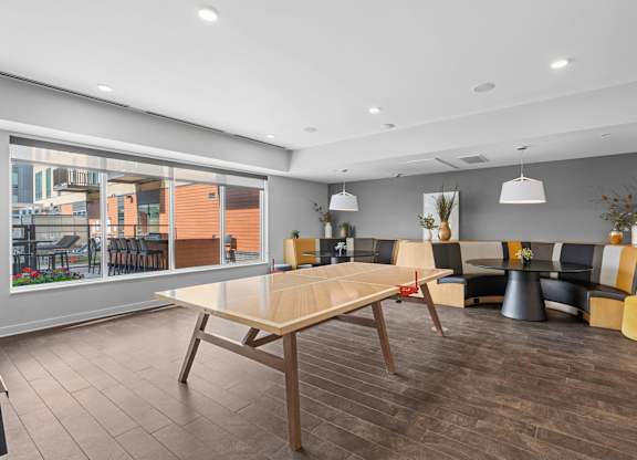 A modern dining room with a long table and chairs.