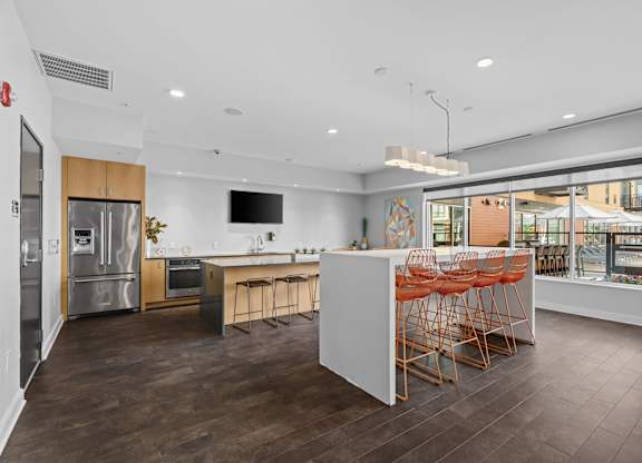 A modern kitchen with a white island and wooden floors.