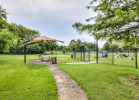 A park with a picnic table and a playground.