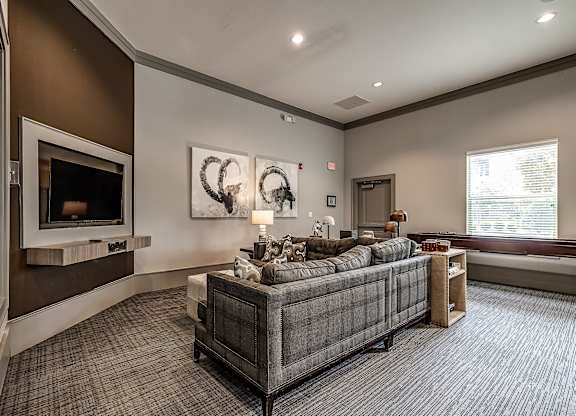 A living room with a grey couch and a fireplace.