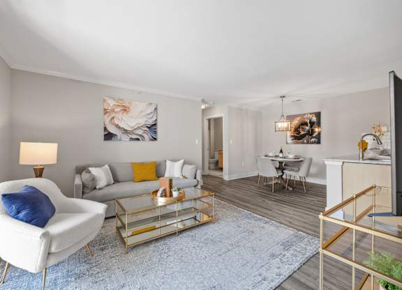 A living room with a white chair and a blue rug.