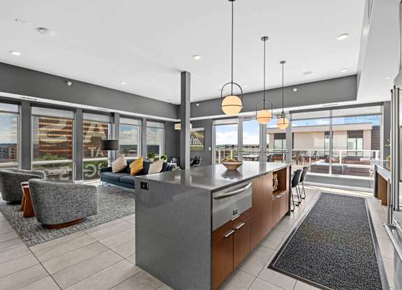 A modern kitchen with a large island and a view of the outdoors.