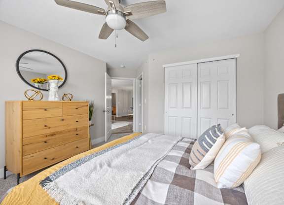 A bedroom with a bed, dresser, and mirror.