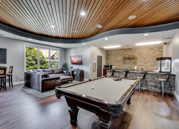 a game room with a pool table and a bar