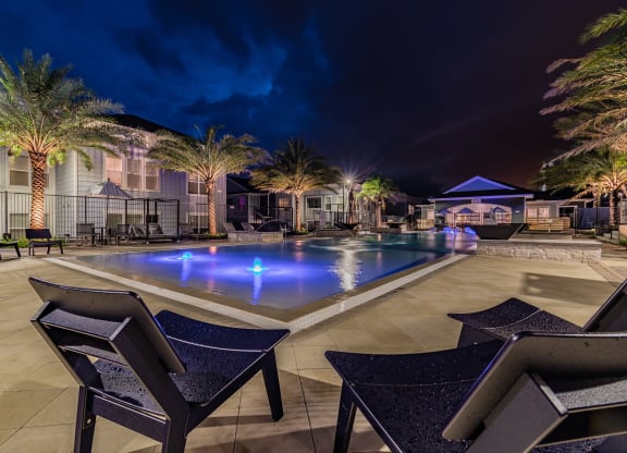 Expansive Outdoor Pool Sundeck Lit Up At Night
