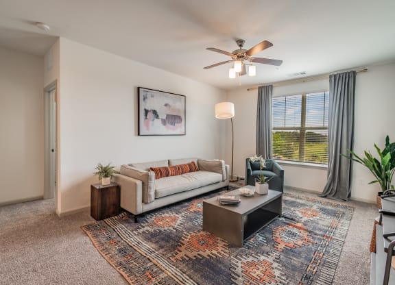 Carpeted Living Room With Tall Ceilings & Large Windows