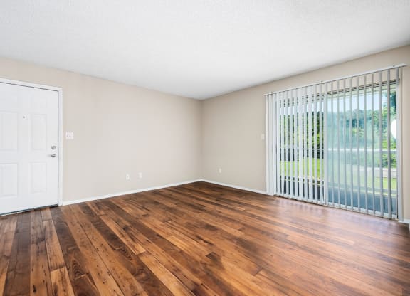 Living Room Area With Wood-Style Flooring & Glass Sliding Patio Door With Built-In Blinds