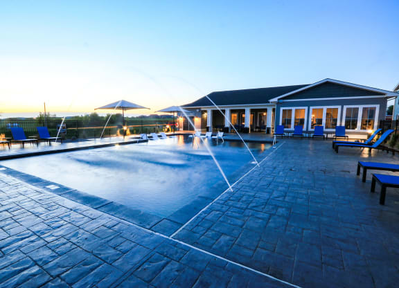 Resort-Style Pool With Fountains At Dusk