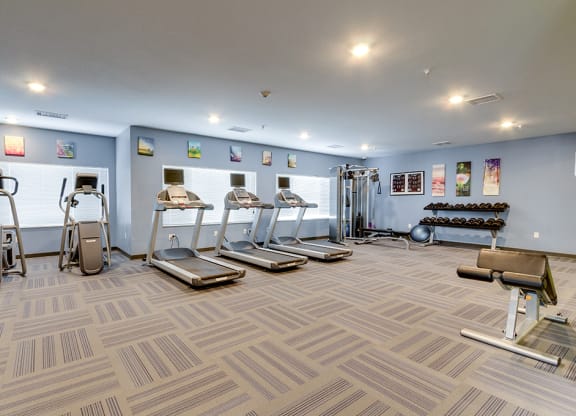 a gym with cardio machines and weights on the floor