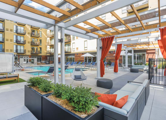 a communal area with couches and plants in front of an apartment building