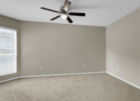 Spacious Carpeted Bedroom With Ceiling Fan