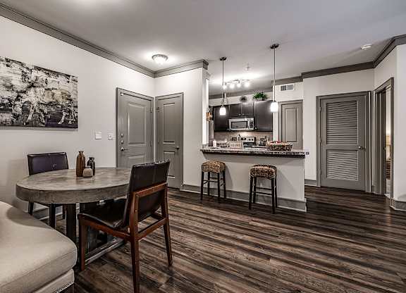 A modern kitchen with a dining table and chairs.