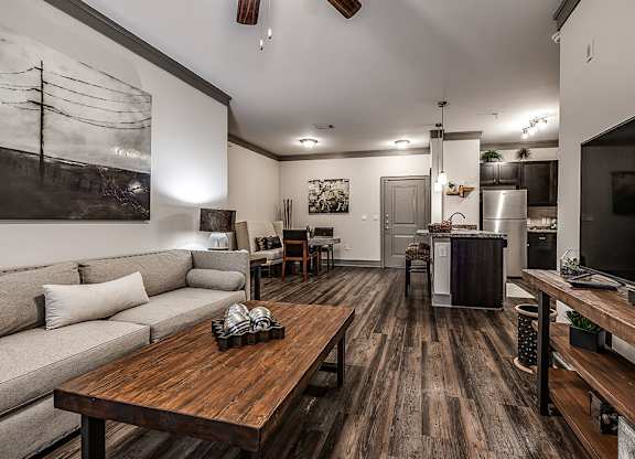 A modern living room with a wooden floor and a grey sofa.