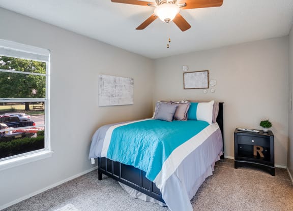 Bedroom with Large Window and Ceiling Fan with Light