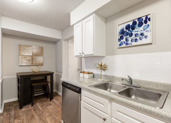 Renovated Kitchen with White Cabinets and Light Grey Countertops with High Top Table in the Dining Room