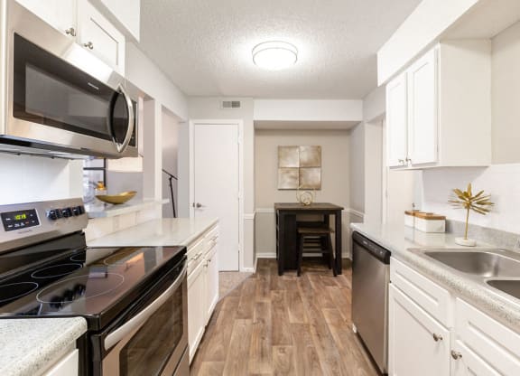 Renovated Kitchen with Stainless Steel Appliances, White Cabinets and Wood Style Flooring