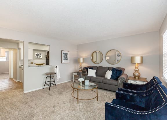 Kitchen with Breakfast Bar Opening Up to Carpeted Living Room