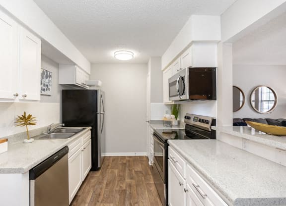 Renovated Galley Kitchen with White Cabinets and Stainless Steel Appliances