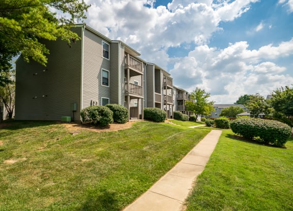 Exterior Of Apartment Homes With Lush Green Grass