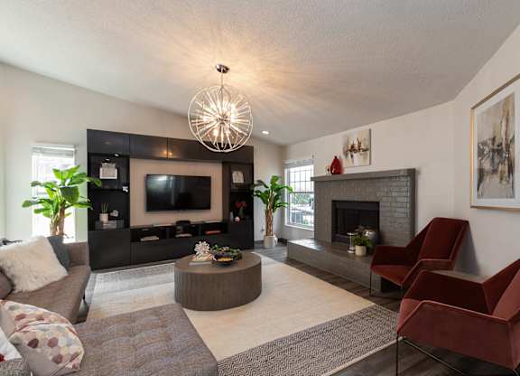 A community room with a fireplace, couches, and a television.