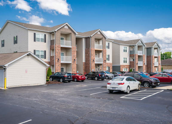 a parking lot with cars in front of an apartment building