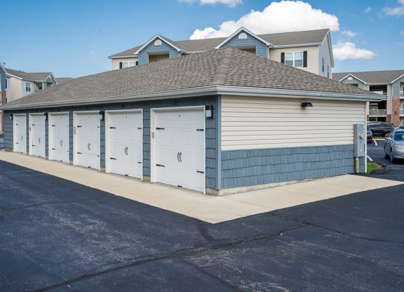 a small garage with four doors on the side of a street