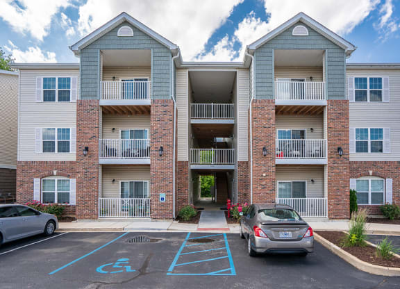 an apartment building with two cars parked in front of it
