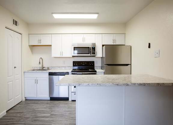 A kitchen with white cabinets and appliances.