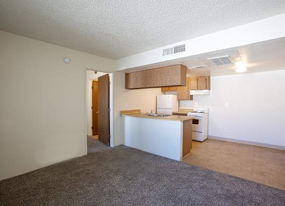 A kitchen area with a white counter and a white refrigerator.