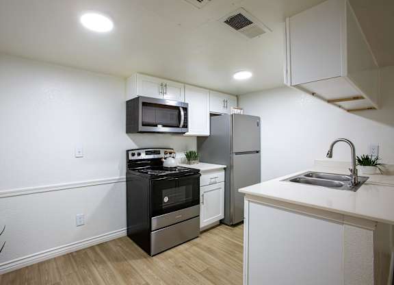 A kitchen with white cabinets and a black stove top oven.