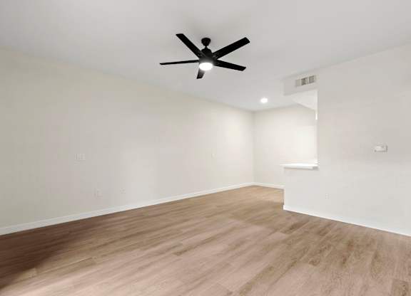 A room with a ceiling fan and light switches on the wall.