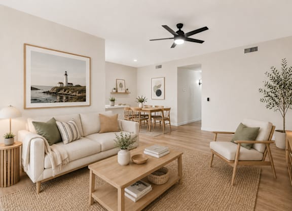 A living room with a white couch, a wooden coffee table, and a ceiling fan.