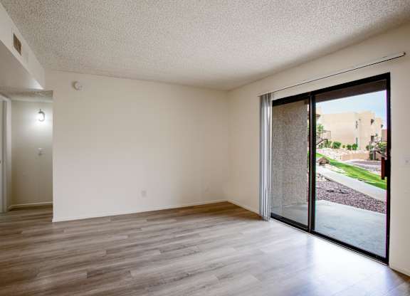 A room with a sliding glass door leading to a backyard.