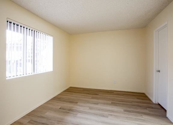 A room with a white door and a window with blinds.