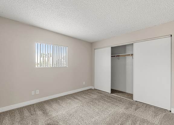 A room with a carpeted floor and a sliding door.