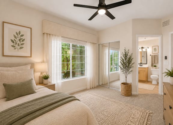 A bedroom with a large bed and a ceiling fan.