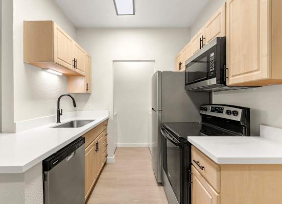 A kitchen with wooden cabinets and black appliances.
