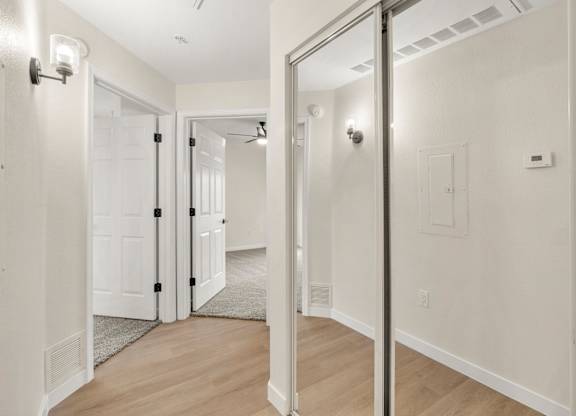 A hallway with white walls and a wooden floor.