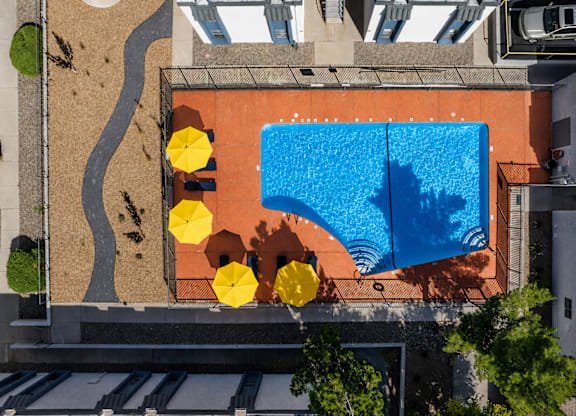 A small pool surrounded by yellow chairs.