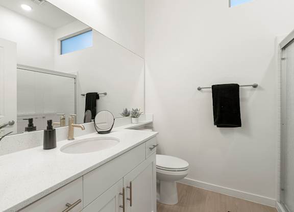 A white bathroom with a toilet and sink.