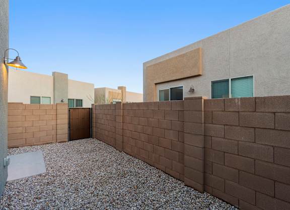 A courtyard with a wall and a lamp post.