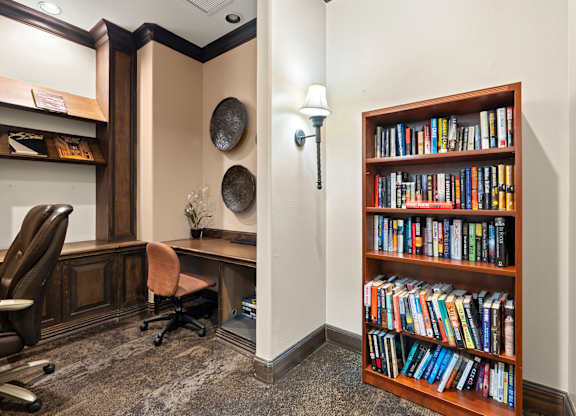 A room with a bookshelf filled with books and a desk with a chair.