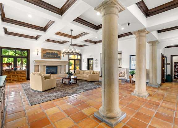 A large room with a fireplace and a chandelier.