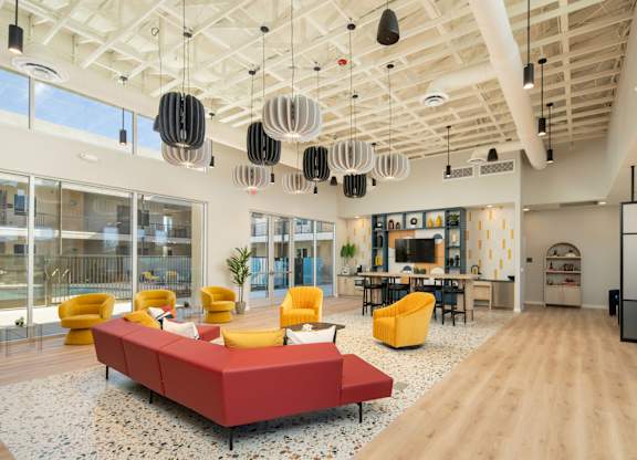 A modern living room with a red sofa and yellow chairs.